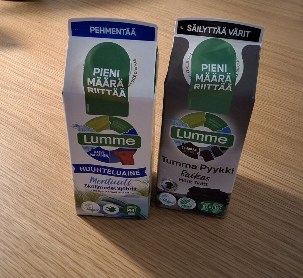 Maitotölkin muotoiset pahvitölkit, tummalle pyykille ja huuhteluaine.